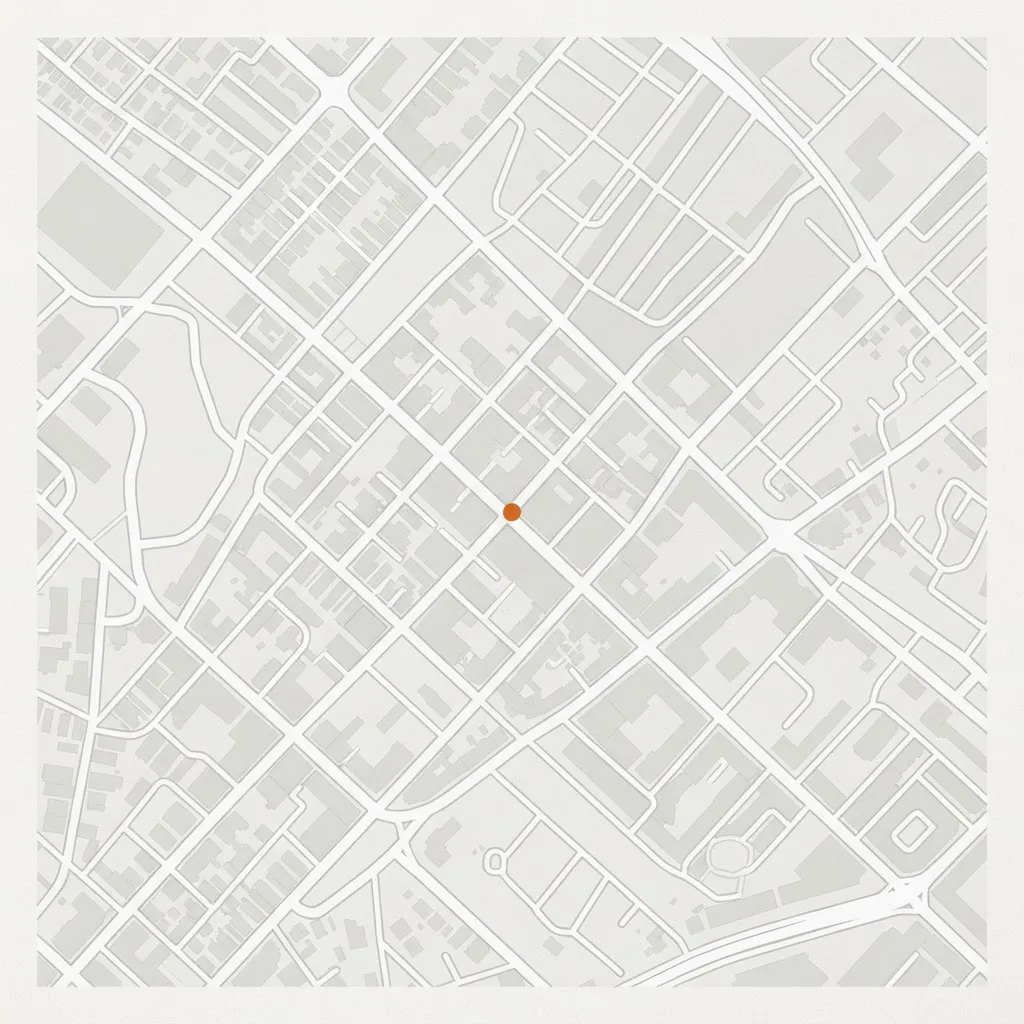 彩度を落としたグレースケール調の地図。灰白の地に、道路は白、建物は淡いグレー。店の位置にのみ熾火色の小さな円（直径8px）を1点。